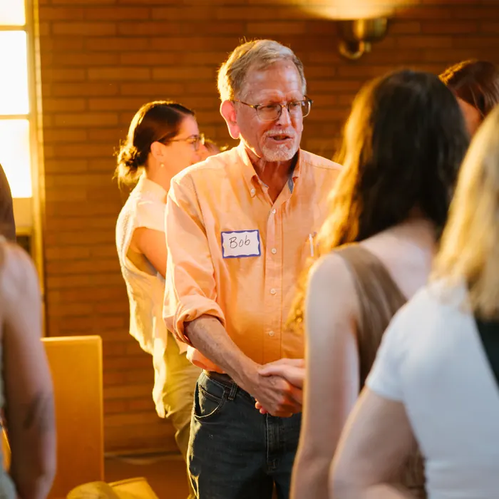 A longtime member greets people in the pews after the service