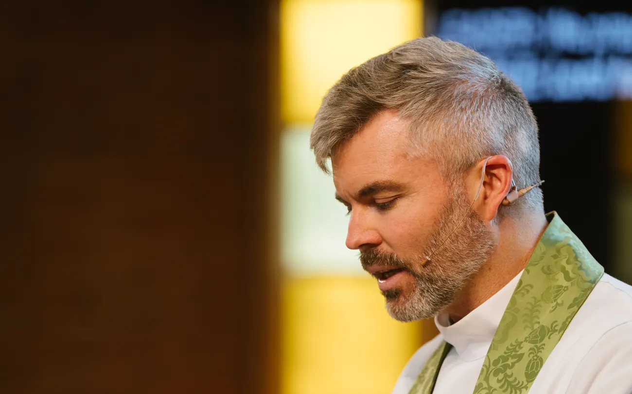 The priest reads from the Bible during the service